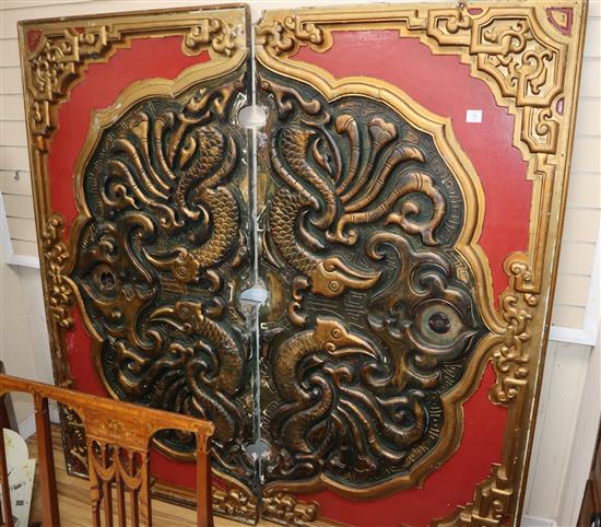 A carved Chinese style painted wood and composition two section panel decorated with mythical dragons total size 180cm square